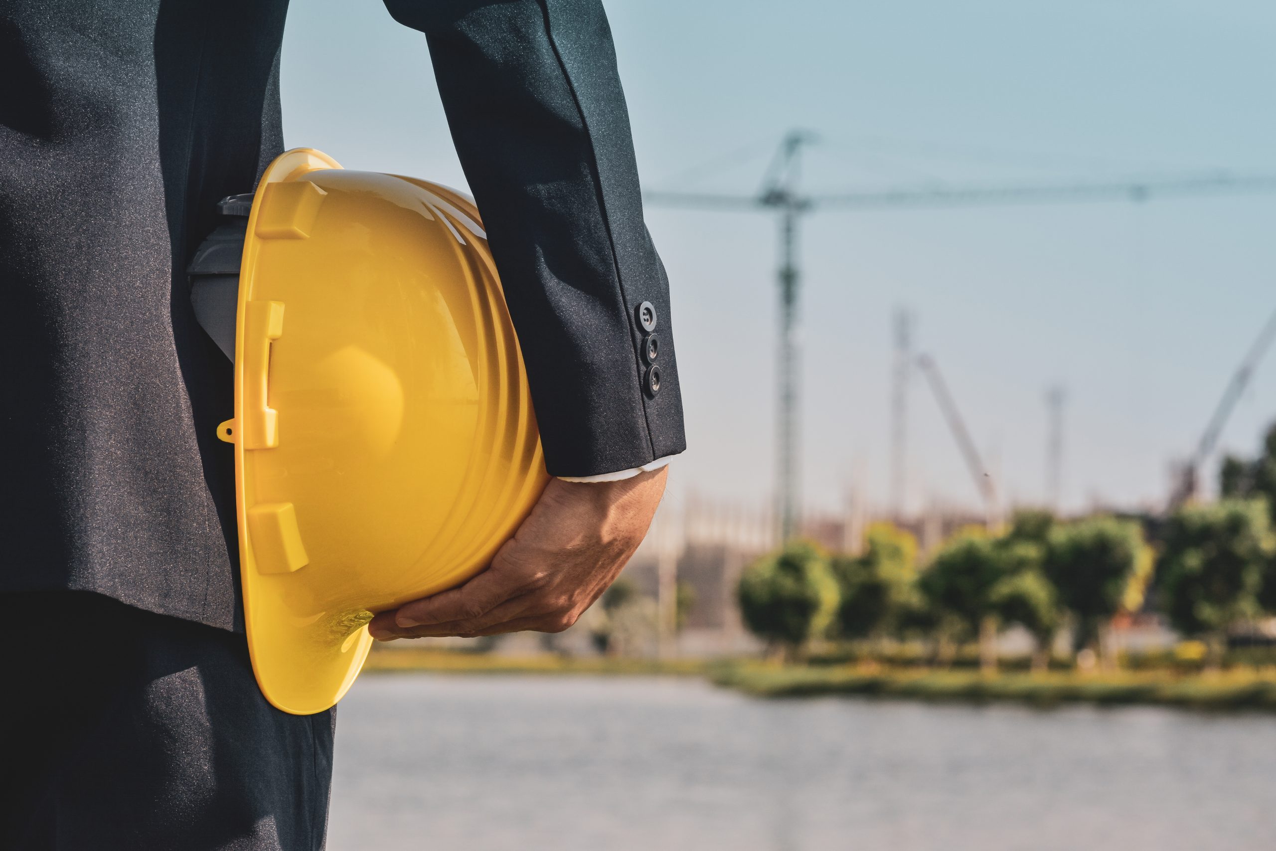 Businessman holding hard hat on site construction
